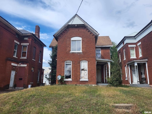 view of front of property with a front lawn and brick siding