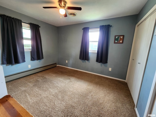 spare room with a baseboard heating unit, ceiling fan, and carpet flooring