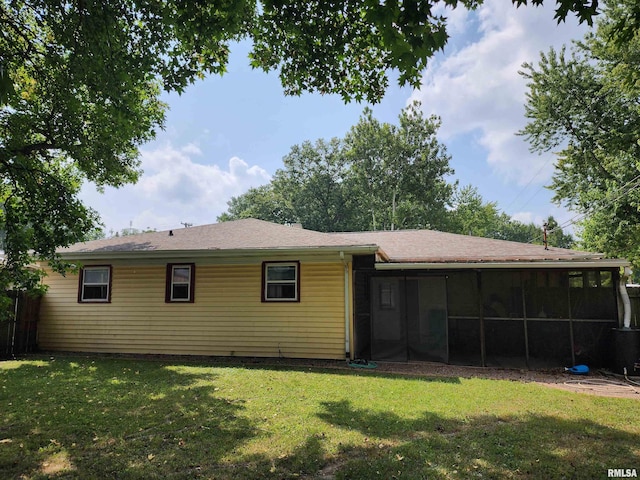 rear view of house with a sunroom and a lawn