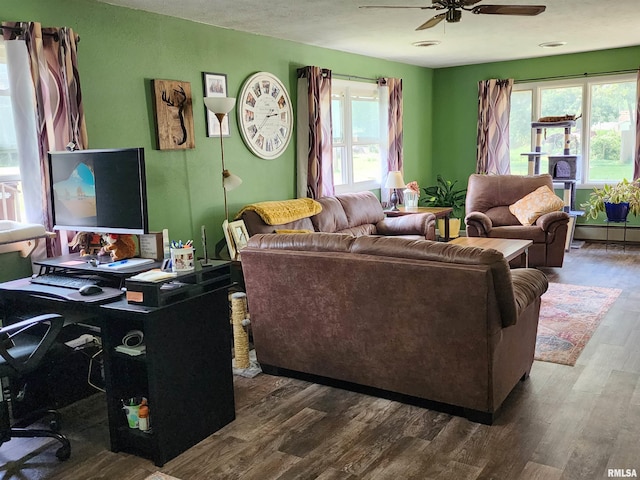 living room featuring a baseboard heating unit, ceiling fan, and dark hardwood / wood-style floors