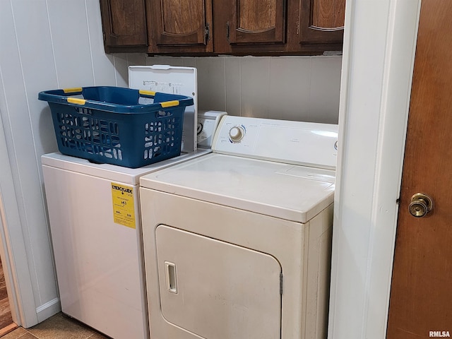 laundry area with light tile patterned flooring, independent washer and dryer, and cabinets