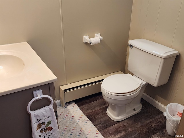 bathroom featuring wood-type flooring, vanity, toilet, and a baseboard heating unit