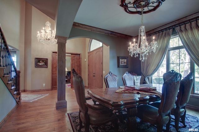 dining space with an inviting chandelier, light hardwood / wood-style flooring, and decorative columns