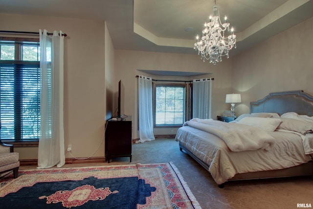 bedroom featuring carpet floors, a raised ceiling, and a notable chandelier