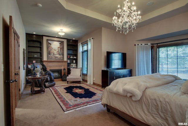 carpeted bedroom featuring an inviting chandelier and a tray ceiling