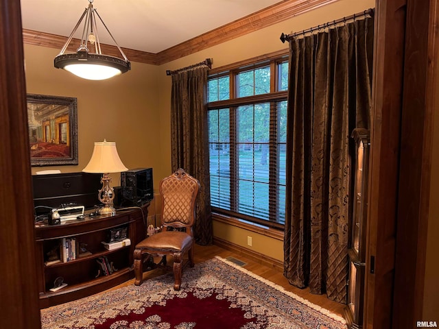 living area with hardwood / wood-style flooring and ornamental molding