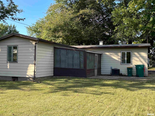 exterior space featuring central air condition unit and a lawn