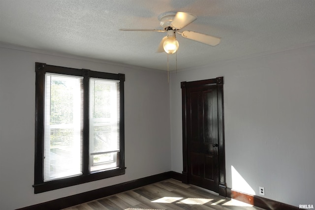 spare room with a textured ceiling, dark hardwood / wood-style floors, and ceiling fan