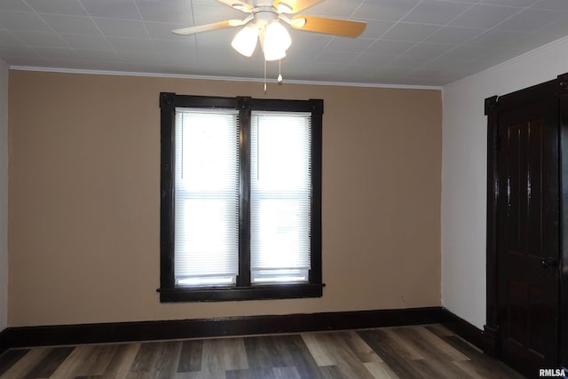 unfurnished room with ornamental molding, ceiling fan, and dark wood-type flooring