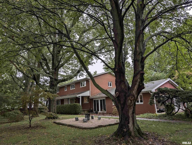 exterior space featuring a front lawn and brick siding