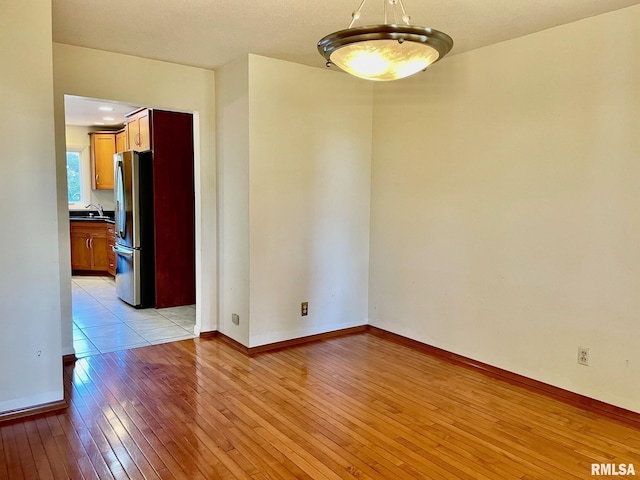 empty room with sink and light hardwood / wood-style flooring