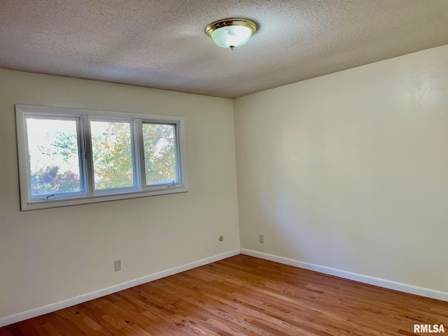 empty room featuring light hardwood / wood-style floors and a textured ceiling