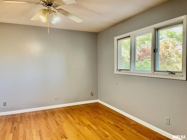 empty room featuring a textured ceiling, ceiling fan, and light wood-type flooring