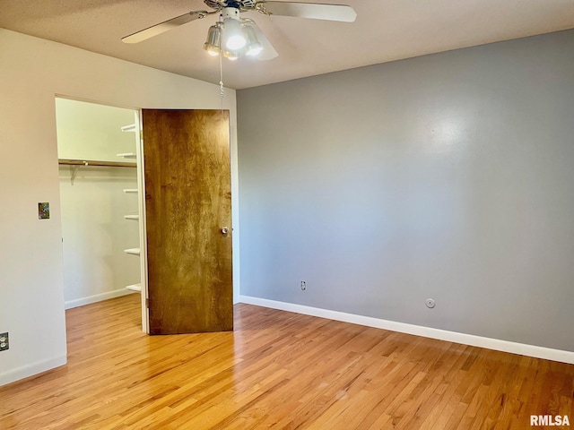 unfurnished bedroom featuring ceiling fan, a closet, and light wood-type flooring