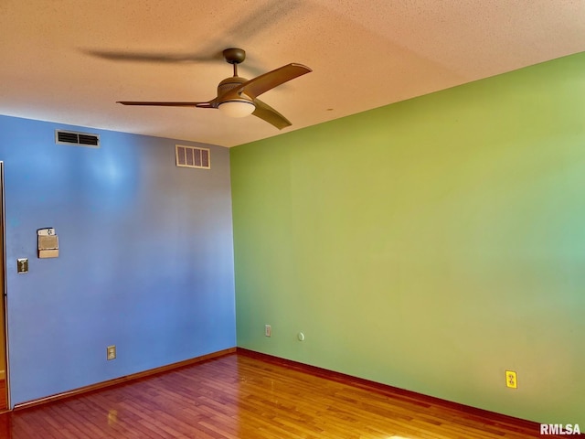 empty room featuring ceiling fan, light hardwood / wood-style flooring, and a textured ceiling