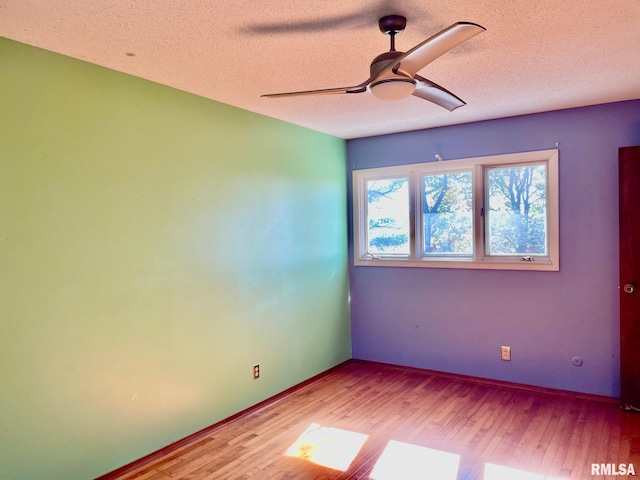 spare room with ceiling fan, hardwood / wood-style floors, and a textured ceiling