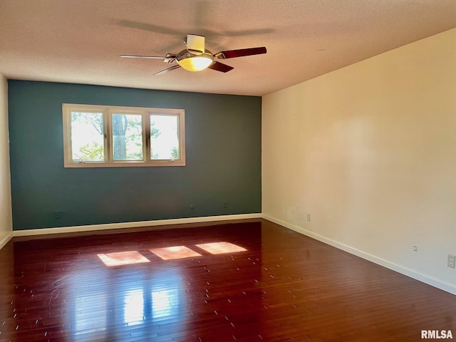 unfurnished room featuring dark hardwood / wood-style flooring, ceiling fan, and a textured ceiling