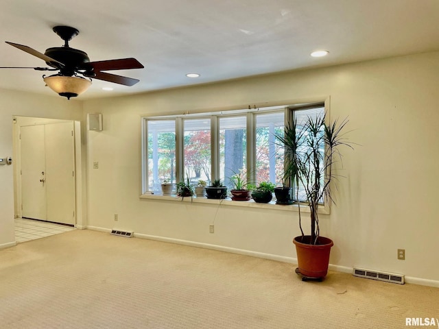 spare room with ceiling fan and light carpet