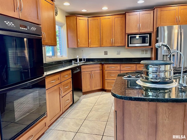 kitchen featuring sink, light tile patterned floors, black appliances, and dark stone counters