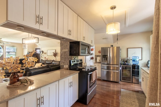 kitchen featuring hanging light fixtures, stainless steel appliances, and white cabinets