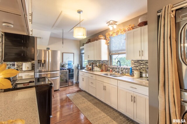 kitchen featuring sink, backsplash, dark wood-type flooring, stainless steel fridge with ice dispenser, and white cabinetry