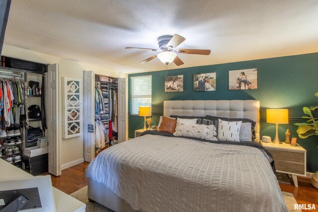 bedroom with a textured ceiling, ceiling fan, a closet, and hardwood / wood-style flooring