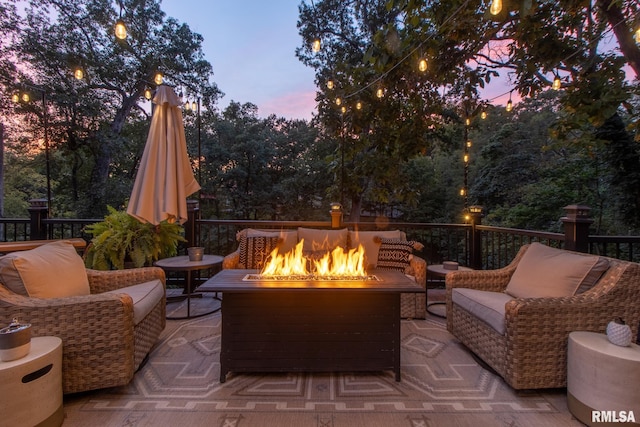 patio terrace at dusk with an outdoor living space with a fire pit