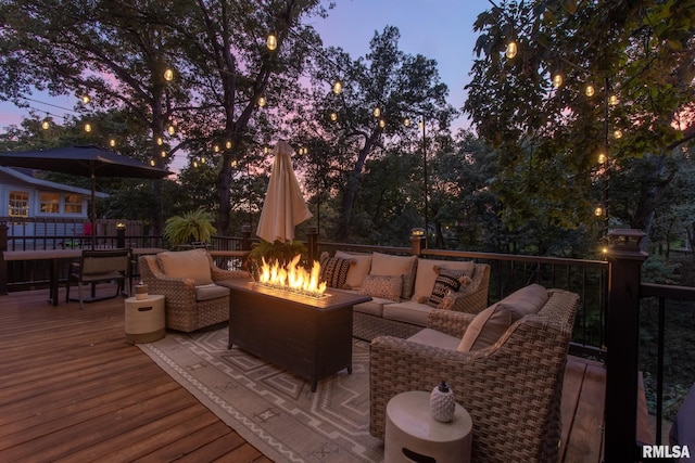 deck at dusk featuring an outdoor living space with a fire pit