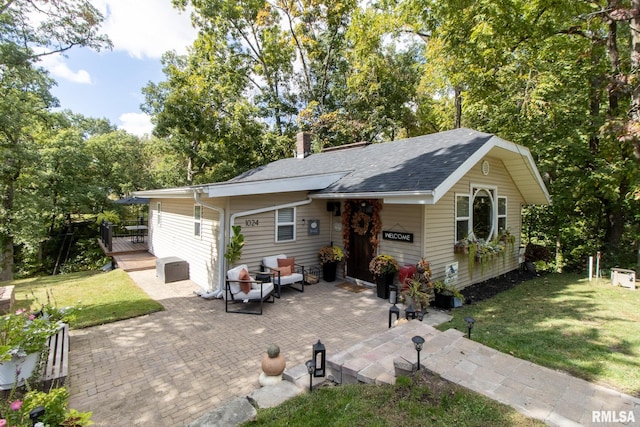 ranch-style house with a front lawn and a patio