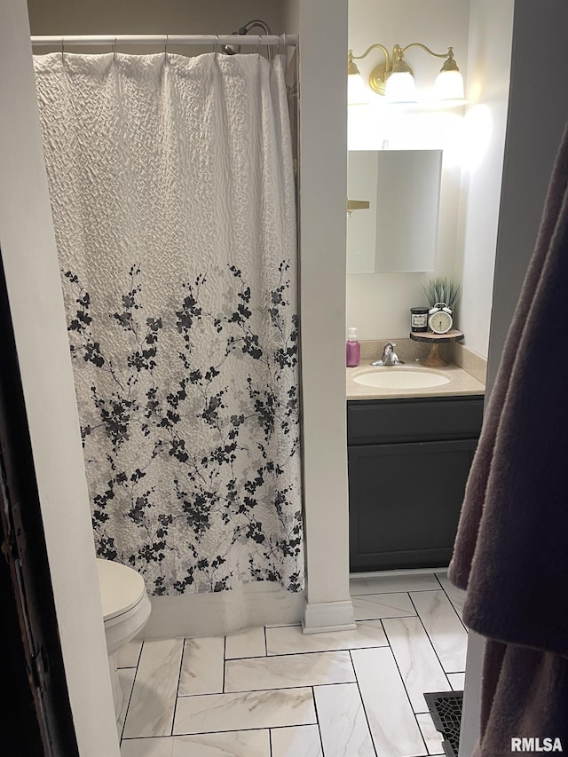 bathroom featuring toilet, marble finish floor, vanity, and a shower with curtain