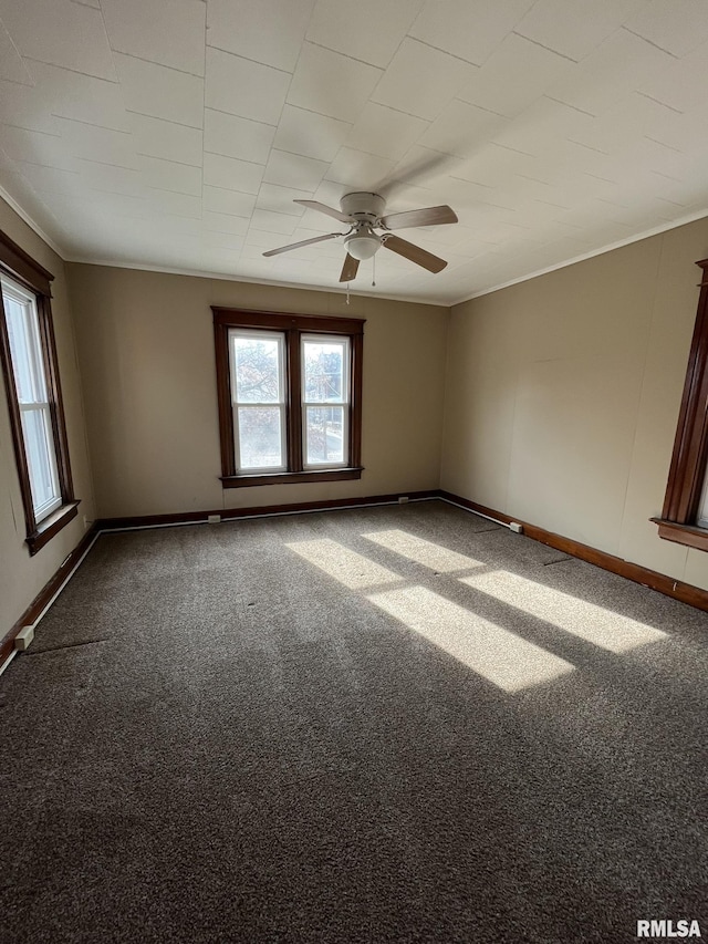 spare room featuring carpet floors, baseboards, crown molding, and ceiling fan