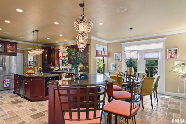 kitchen featuring pendant lighting, stainless steel appliances, sink, and a kitchen island