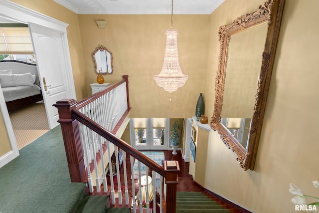 stairway with carpet, ornamental molding, and an inviting chandelier