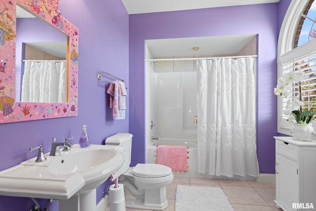 full bathroom featuring shower / bath combination with curtain, sink, tile patterned flooring, and toilet