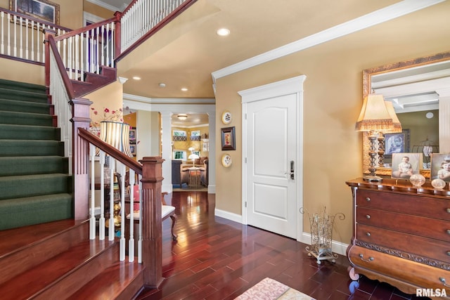 entrance foyer featuring ornamental molding, dark hardwood / wood-style flooring, and ornate columns