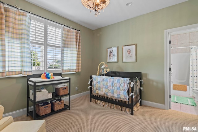 bedroom with light carpet, a notable chandelier, and ensuite bathroom