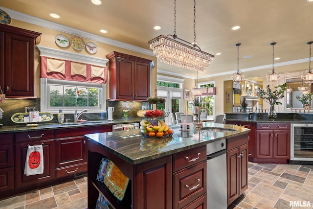 kitchen with beverage cooler, decorative light fixtures, plenty of natural light, and a center island