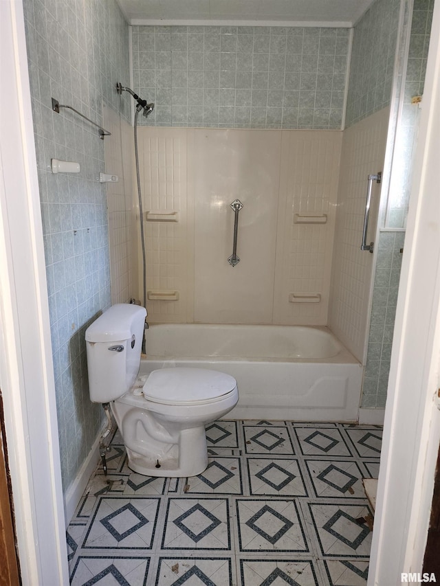 bathroom featuring tile patterned flooring, toilet, and tiled shower / bath