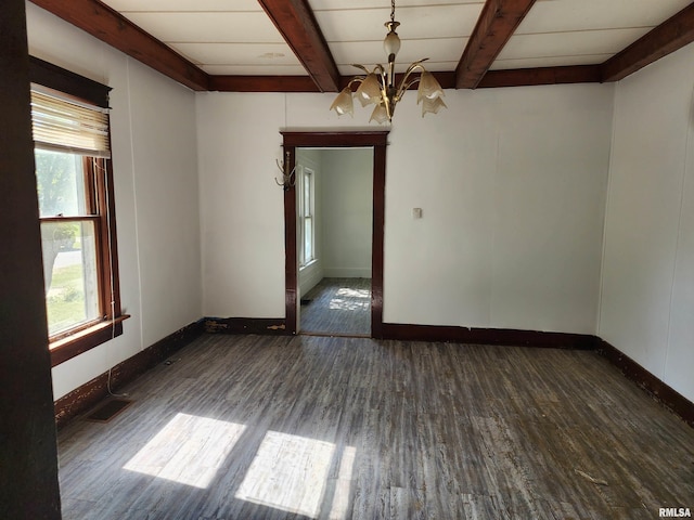 empty room featuring beamed ceiling, dark hardwood / wood-style floors, and plenty of natural light