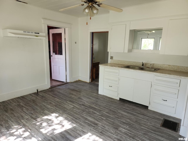 kitchen with white cabinetry, a wall mounted air conditioner, dark hardwood / wood-style floors, and sink