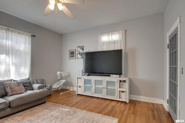 living room featuring a textured ceiling, ceiling fan, and hardwood / wood-style flooring