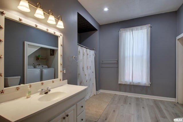 bathroom with separate washer and dryer, vanity, toilet, and hardwood / wood-style flooring