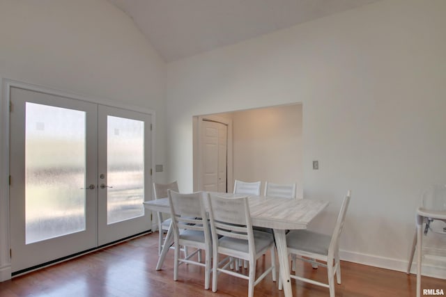 dining space featuring light wood-type flooring, lofted ceiling, and french doors