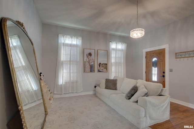 living room with light hardwood / wood-style floors, an inviting chandelier, and plenty of natural light