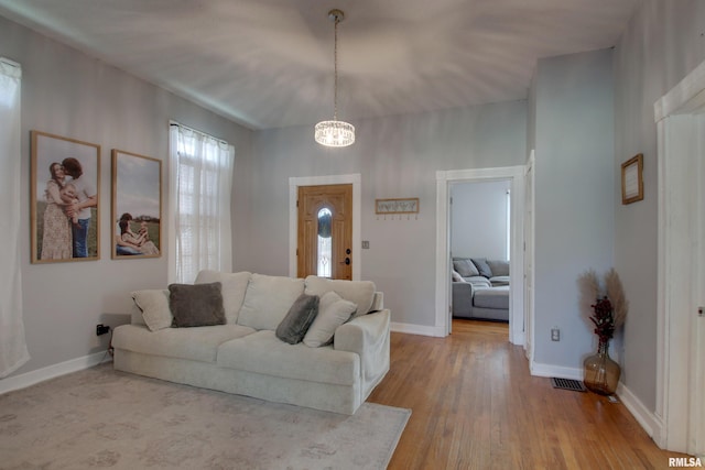 living room featuring light hardwood / wood-style flooring and a notable chandelier