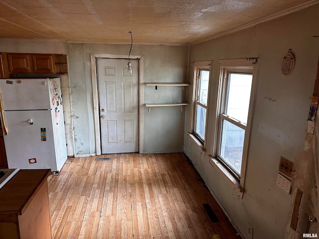 kitchen with light wood-type flooring, plenty of natural light, and white fridge