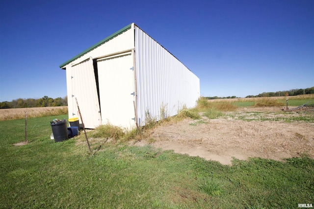 view of outbuilding featuring a yard and a rural view