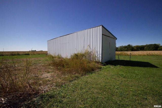 view of outdoor structure featuring a lawn and a rural view