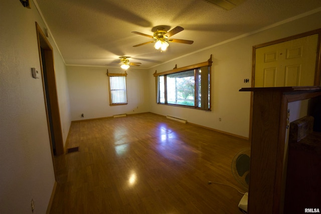 empty room featuring baseboard heating, a textured ceiling, ceiling fan, hardwood / wood-style flooring, and ornamental molding