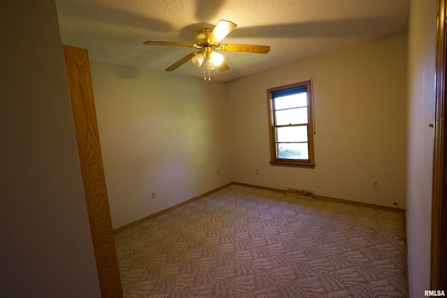 unfurnished room with light carpet, ceiling fan, and a textured ceiling